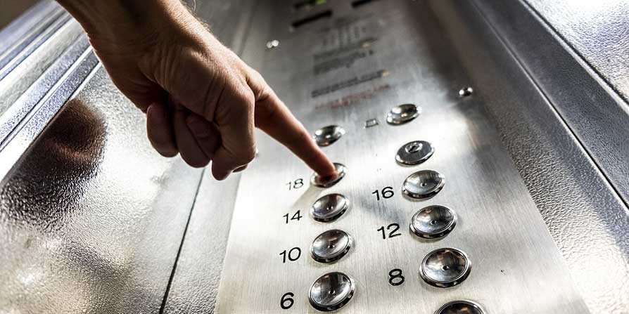 View of a person's finger pressing a button in a lift